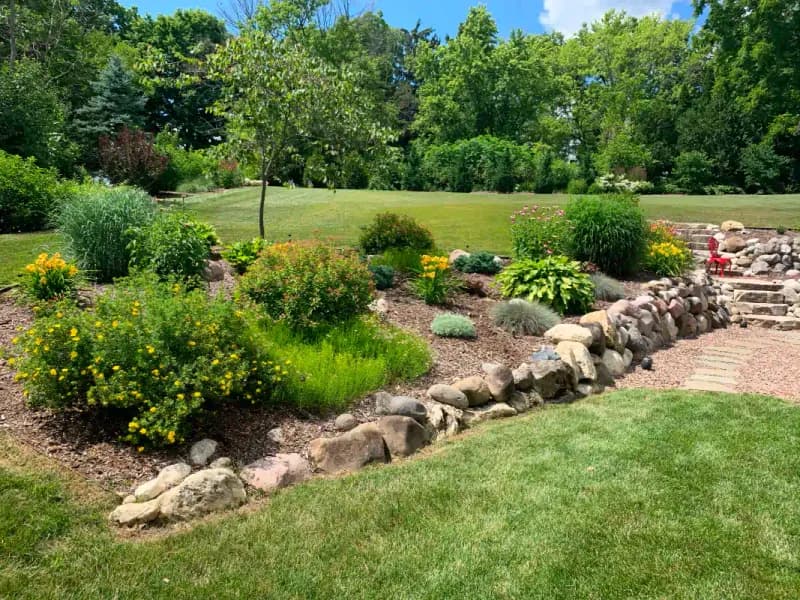 Mature perennial flower garden with natural stone border