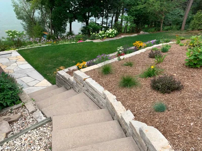 Lakefront terraced landscape with stone steps and perennial gardens