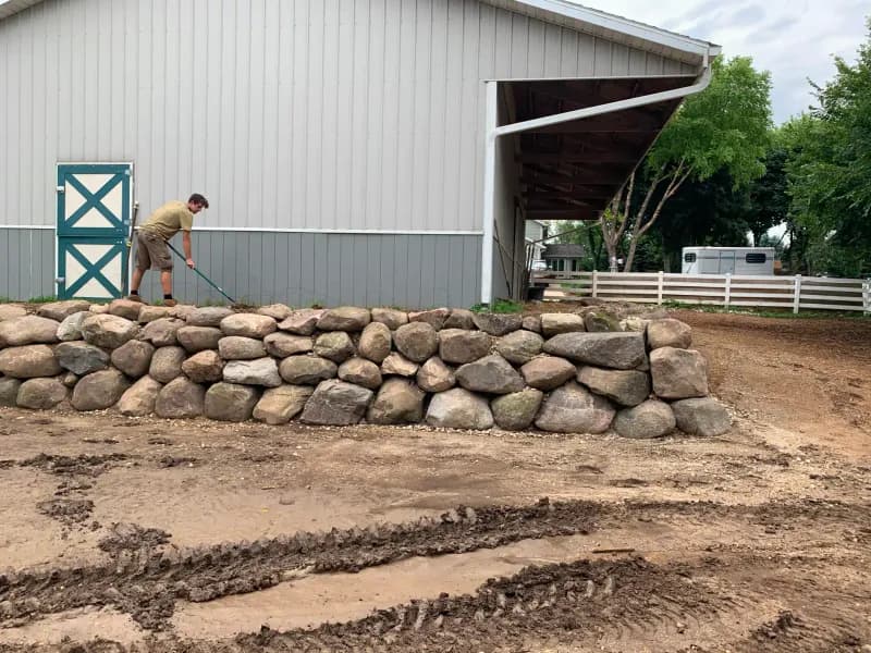 Natural boulder retaining wall with paver patio